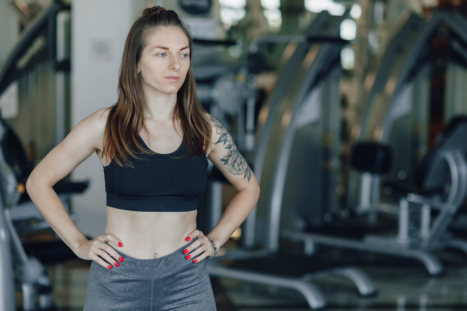 Attractive athletic girl stands on the background of simulators in the gym. healthy lifestyle and wellness.